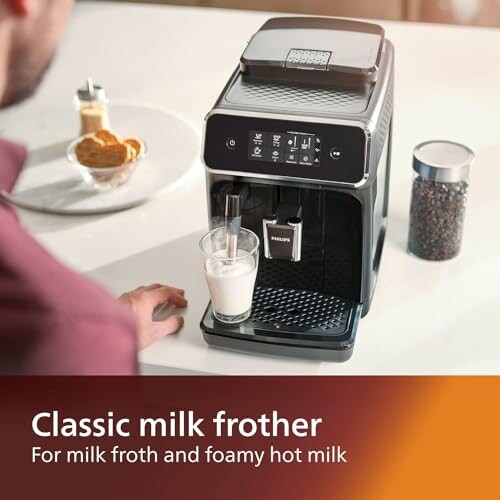 Person using a classic milk frother machine on a kitchen counter.