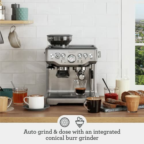 Coffee machine with integrated conical burr grinder on kitchen counter with cups and bread.