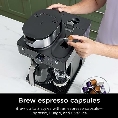 Person using a coffee machine to brew espresso capsules.